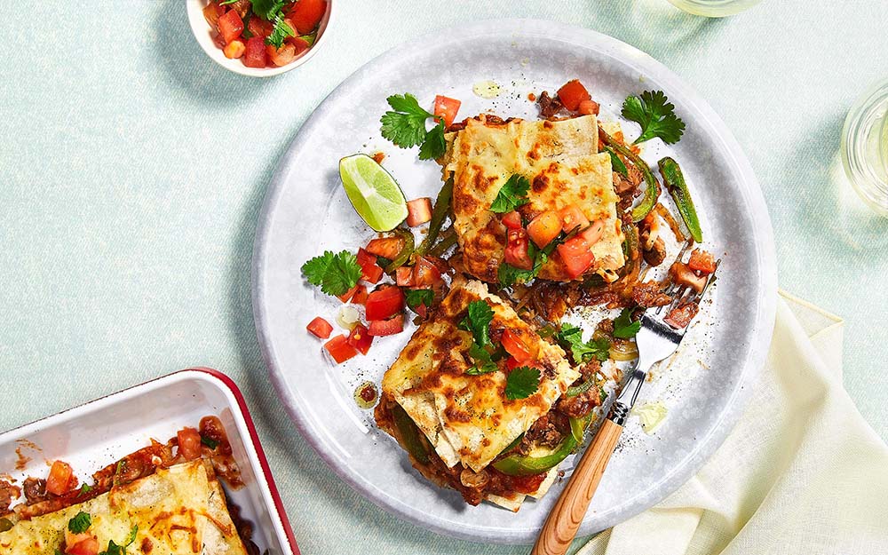 Cheesy Enchilada Bake with creamy layered beans and tomato salsa,